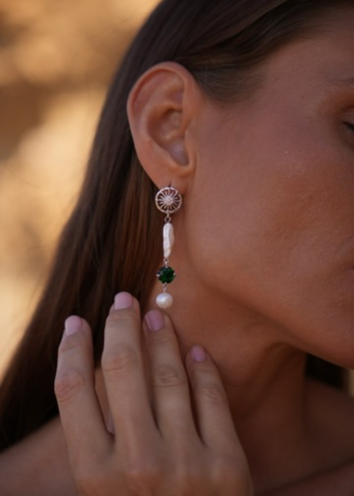 Pendientes asimétricos en tono plateado con perla barroca y detalle verde. Diseño elegante con textura natural para looks de dia o de noche.