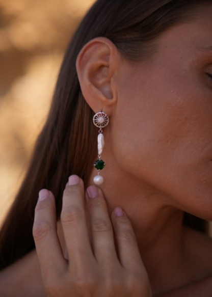 Pendientes asimétricos en tono plateado con perla barroca y detalle verde. Diseño elegante con textura natural para looks de dia o de noche.